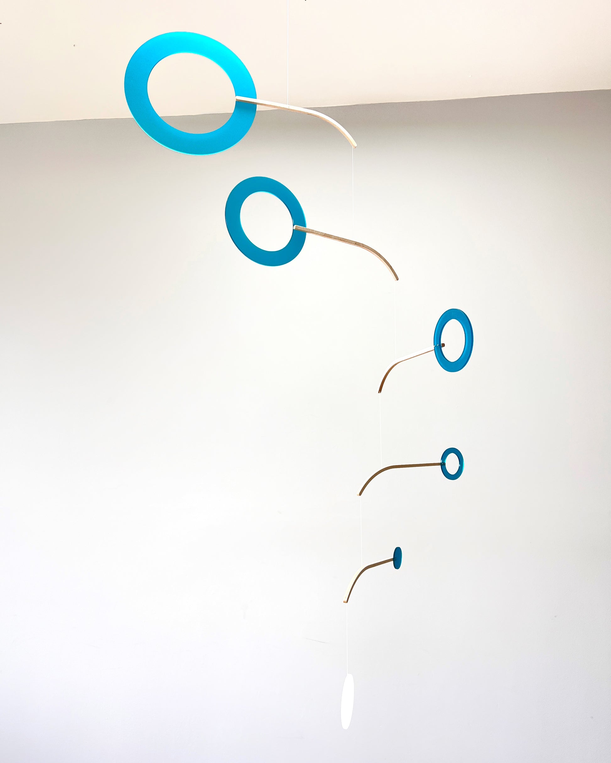 Teal Kinetic Hanging Mobile Sculpture, Minimalistic Circles Adult Mobile Home Decor - Halo Halo Handcrafted By The Illuminist
Introducing Halo Halo Mobile - A stunning piece of kinetic art that will bring movement and interest to any room. Handcrafted from responsibly sourced engineered birch, this unique mobile features six halo rings of increasing width and size in frosted Orange acrylic. Similar to my original Halo mobile but on a verticle plane.