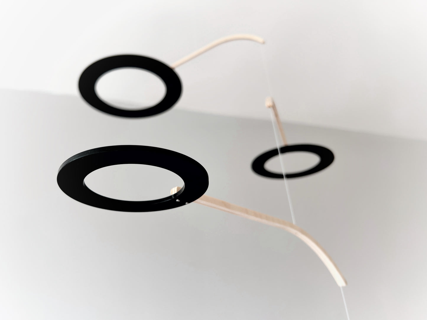 Large Kinetic Mobile Sculpture, Black Hanging Adult Mobile, Mid Century Modern Art Mobile, Calder Minimal Circle Mobile, Halo The Illuminist
Introducing Halo Mobile - A stunning piece of kinetic art that will bring movement and joy to any room. Handcrafted from responsibly sourced engineered birch, this unique mobile features six halo rings of increasing width and size in frosted black acrylic.