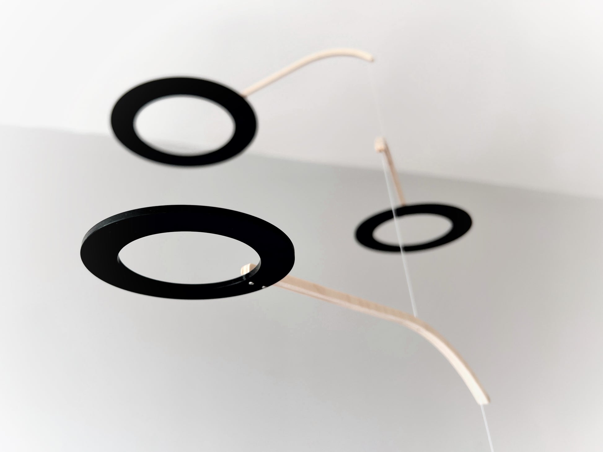 Large Kinetic Mobile Sculpture, Black Hanging Adult Mobile, Mid Century Modern Art Mobile, Calder Minimal Circle Mobile, Halo The Illuminist
Introducing Halo Mobile - A stunning piece of kinetic art that will bring movement and joy to any room. Handcrafted from responsibly sourced engineered birch, this unique mobile features six halo rings of increasing width and size in frosted black acrylic.