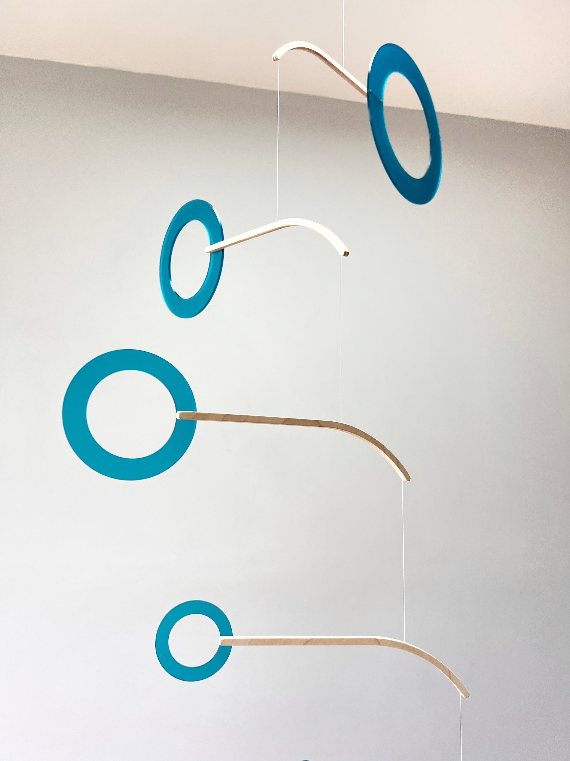 Teal Kinetic Hanging Mobile Sculpture, Minimalistic Circles Adult Mobile Home Decor - Halo Halo Handcrafted By The Illuminist
Introducing Halo Halo Mobile - A stunning piece of kinetic art that will bring movement and interest to any room. Handcrafted from responsibly sourced engineered birch, this unique mobile features six halo rings of increasing width and size in frosted Orange acrylic. Similar to my original Halo mobile but on a verticle plane.
