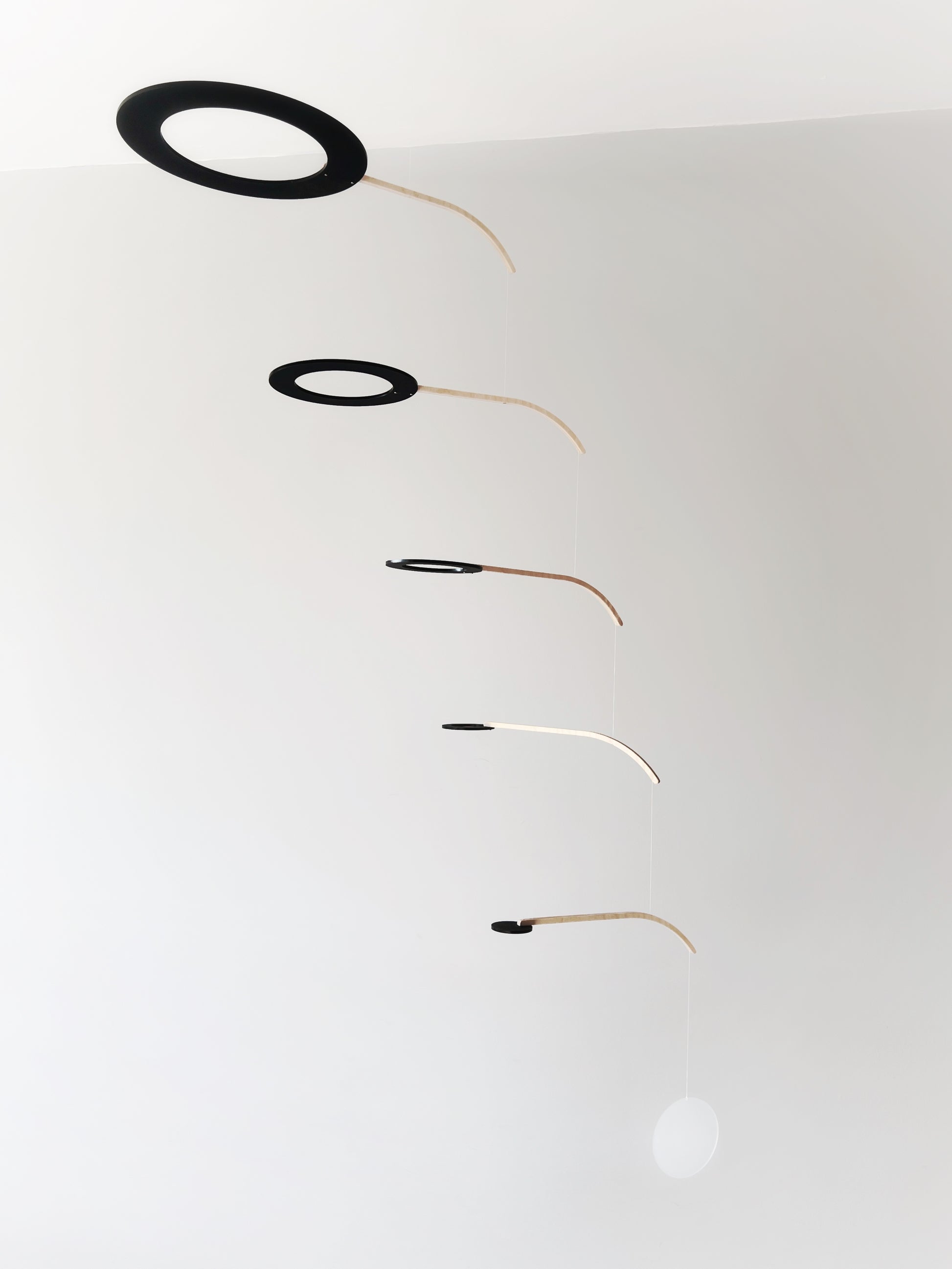 Large Kinetic Mobile Sculpture, Black Hanging Adult Mobile, Mid Century Modern Art Mobile, Calder Minimal Circle Mobile, Halo The Illuminist
Introducing Halo Mobile - A stunning piece of kinetic art that will bring movement and joy to any room. Handcrafted from responsibly sourced engineered birch, this unique mobile features six halo rings of increasing width and size in frosted black acrylic.