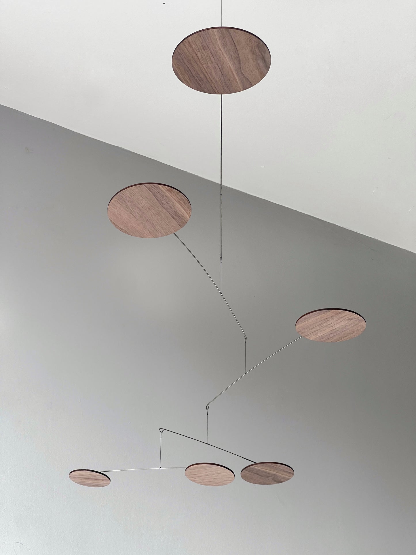 A handcrafted wooden mobile — a modern mobile, inspired by Alexander Calders’ mobile kinetic sculptures for mid century decor lovers. This elegant hanging mobile is a piece of moving art and a mobile for adults, bringing calm motion, balance, and timeless design to your home.
This mid century mobile is a beautifully balanced kinetic mobile, art mobile, and large mobile that drifts gracefully with the air. Handcrafted from fine walnut veneer and stainless steel wire, it combines organic warmth with minimali