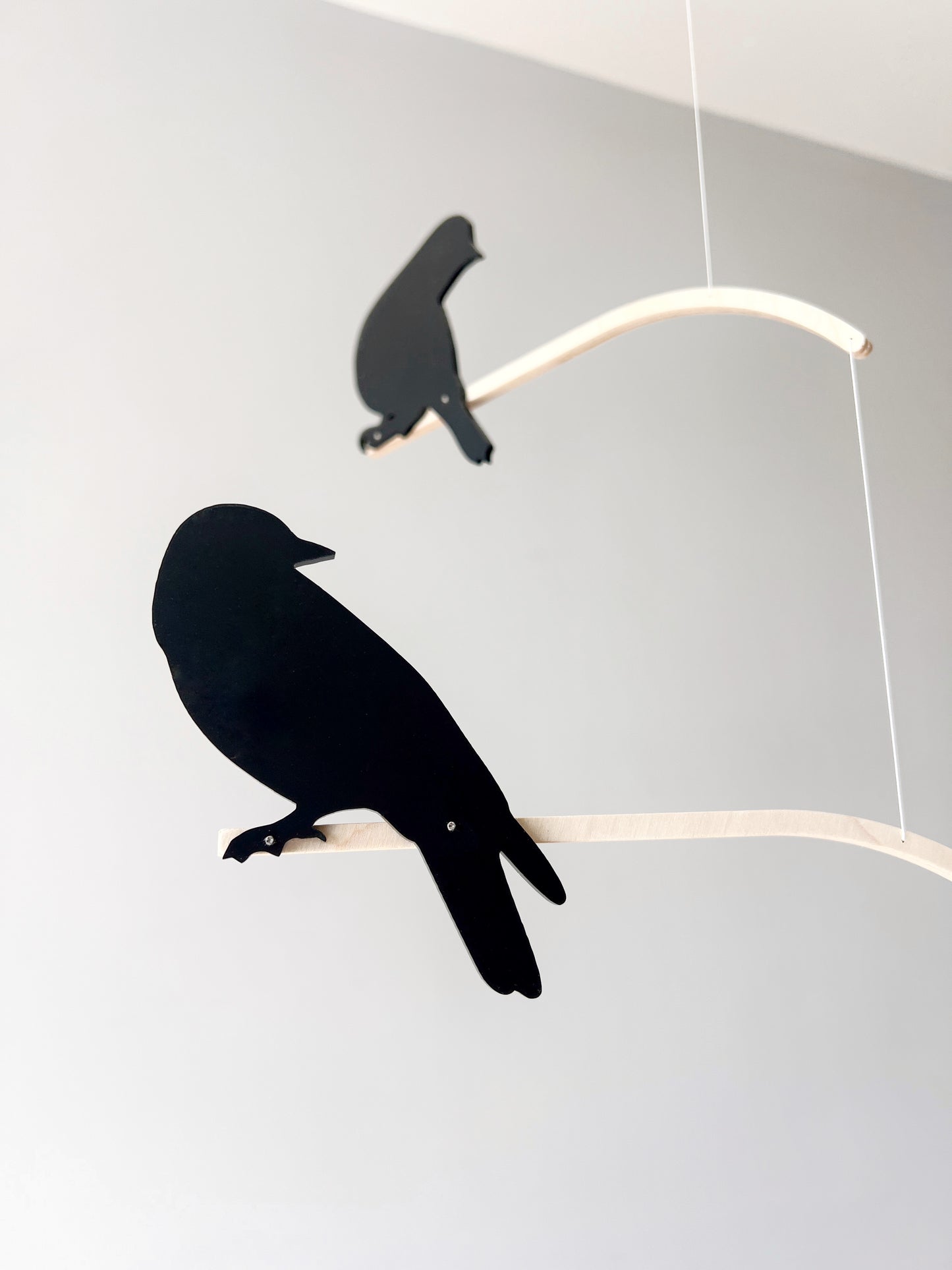 Nosey Bird Kinetic Mobile Sculpture, Adult & Baby Mobile. Hanging Silhouette Wall Art, Counterbalanced Handcrafted Acrylic & Wood Bird Mobile

Introducing ‘Nosey Birds’ - A fun piece of kinetic art that will bring movement and interest to any room. Handcrafted from responsibly sourced engineered birch, this unique mobile features 5 laser cut bird silhouettes of increasing size in a stunning frosted black acrylic. Composed so the birds are looking towards each other while perched on the curved birch arm.