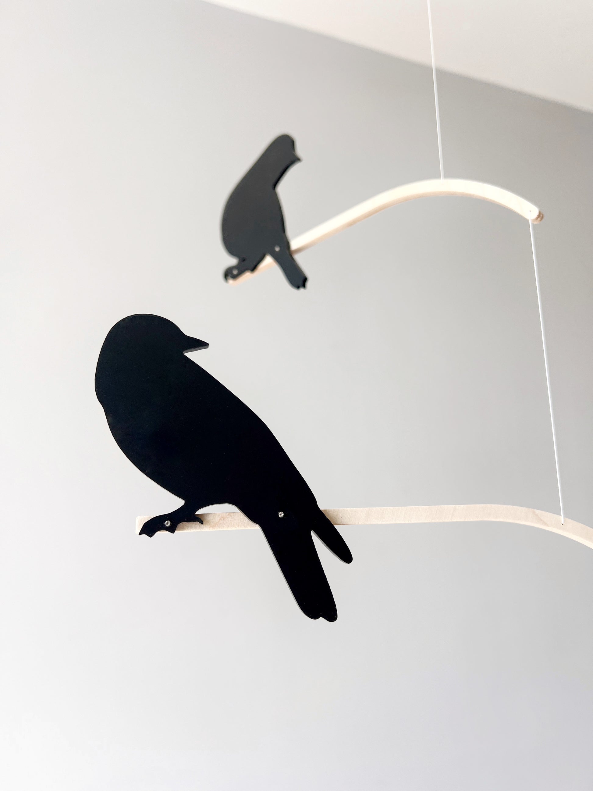 Nosey Bird Kinetic Mobile Sculpture, Adult & Baby Mobile. Hanging Silhouette Wall Art, Counterbalanced Handcrafted Acrylic & Wood Bird Mobile

Introducing ‘Nosey Birds’ - A fun piece of kinetic art that will bring movement and interest to any room. Handcrafted from responsibly sourced engineered birch, this unique mobile features 5 laser cut bird silhouettes of increasing size in a stunning frosted black acrylic. Composed so the birds are looking towards each other while perched on the curved birch arm.