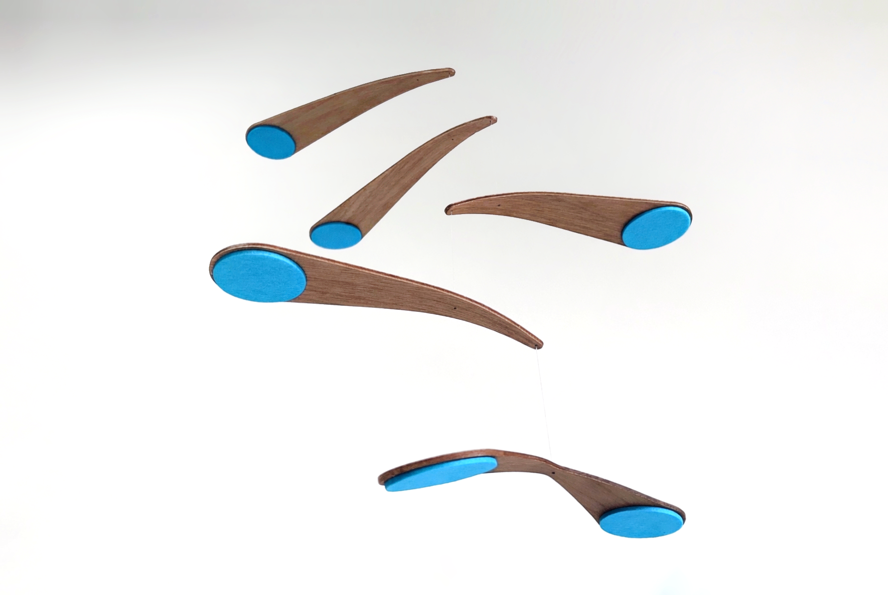 in kingfisher blue this alternative baby mobile in rich walnut wood, featuring curved forms and a floating kinetic structure. This handcrafted nursery decor piece rotates gently, creating a peaceful sensory experience for babies. Inspired by vintage mid century modern design, it works in minimalist and design-led homes. A unique heirloom gift with custom colours available.