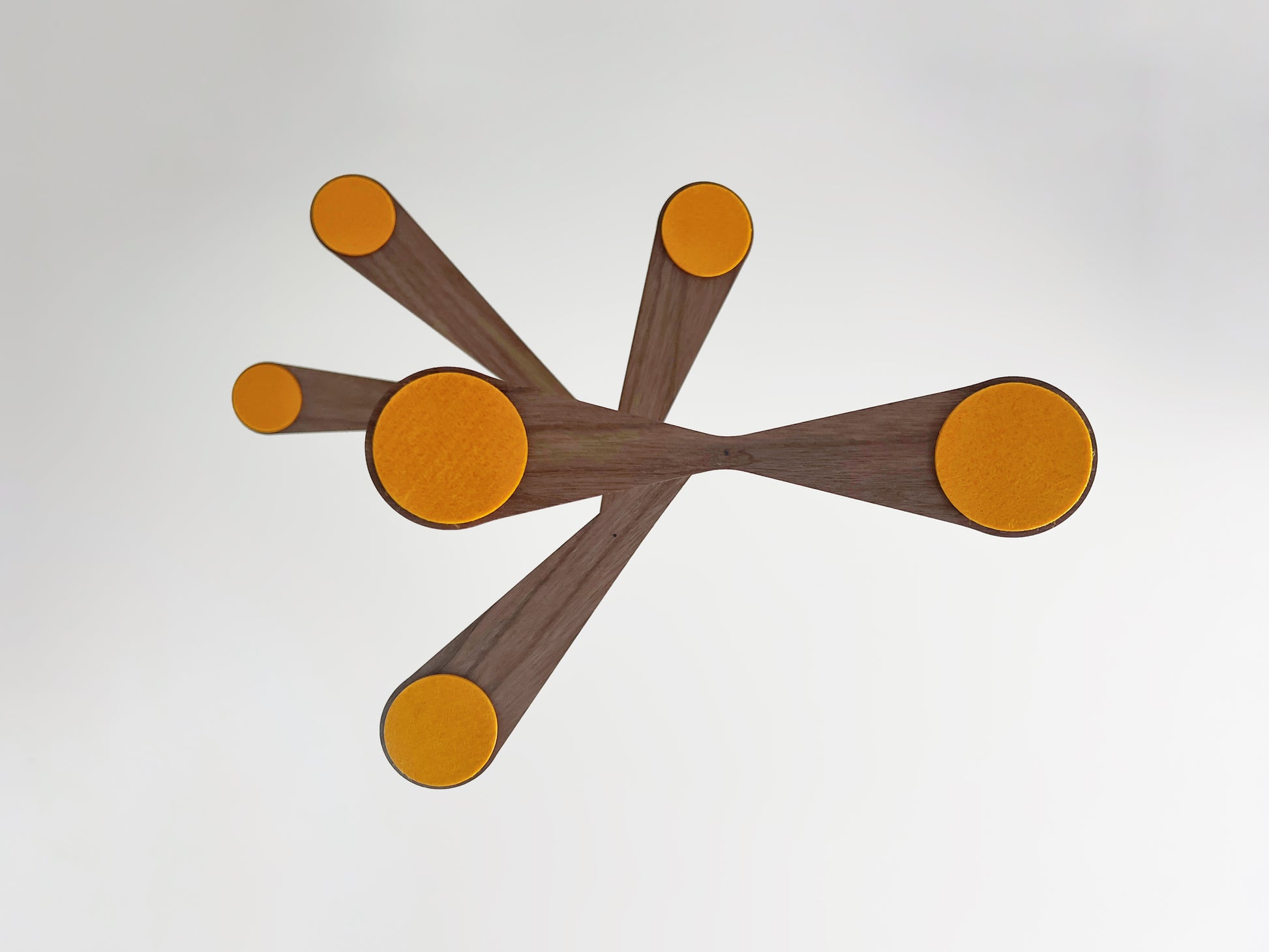 in yellow ochre felt this Alternative baby mobile in rich walnut wood, featuring curved forms and a floating kinetic structure. This handcrafted nursery decor piece rotates gently, creating a peaceful sensory experience for babies. Inspired by vintage mid century modern design, it works in minimalist and design-led homes. A unique heirloom gift with custom colours available.
