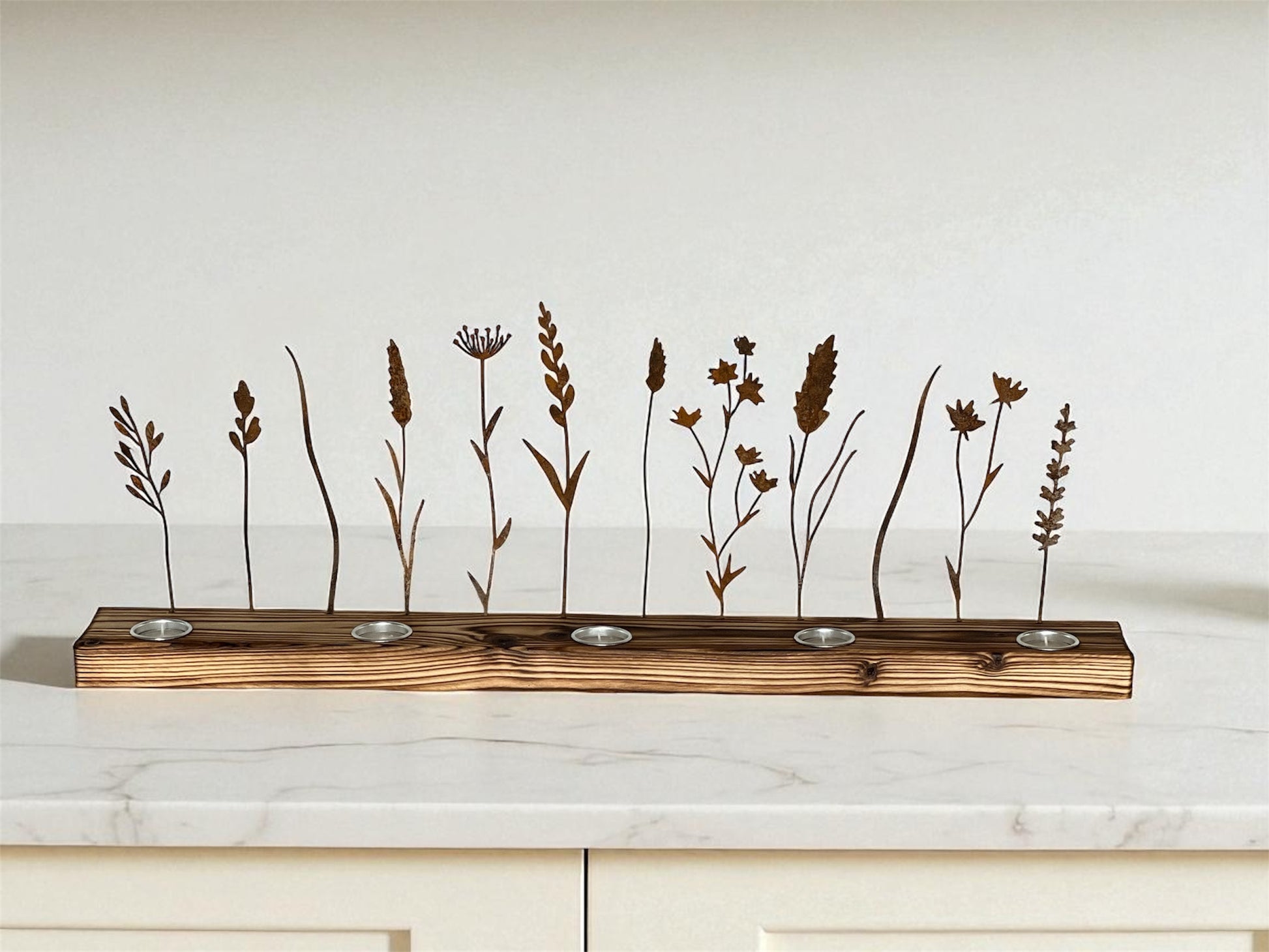 Metal wildflower silhouettes designed to create shadow art with flickering tea light candles