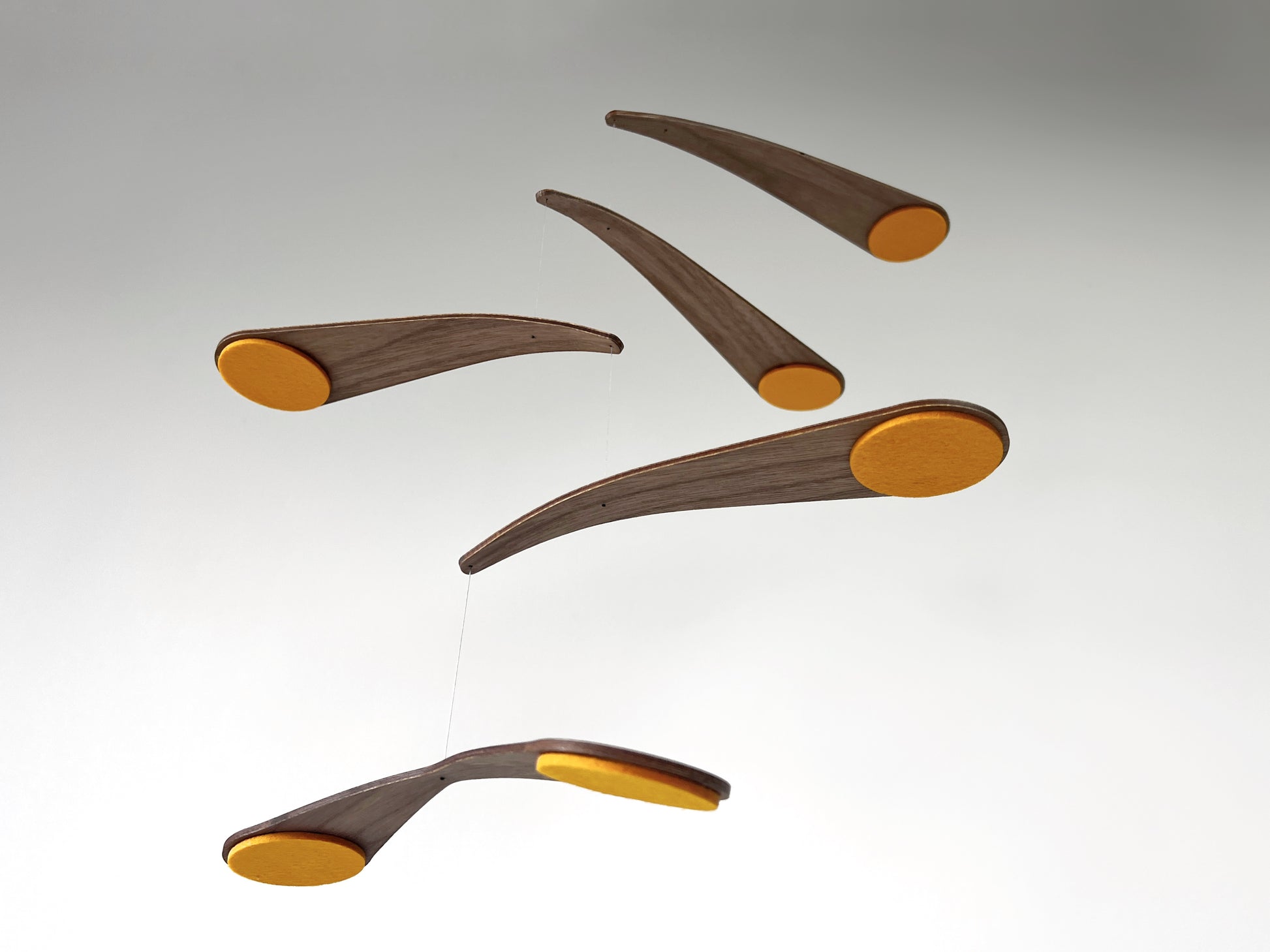 Unique walnut baby mobile combining sculptural design with gentle movement. This kinetic nursery piece rotates in a smooth, balanced motion, creating a calming focal point above a crib or in a living space. Inspired by retro modern art, it suits alternative interiors. Handmade and available in custom colours to match your style.