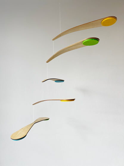 Close-up view of the Bo Mobile nursery mobile showing natural wood arms and wool felt circles in custom colours, carefully balanced to create a floating kinetic effect. This handmade baby mobile is designed to be viewed from below, just like a baby lying in a crib. Perfect for modern nursery decor, Montessori-inspired baby rooms, and minimalist interiors, this spinning mobile brings gentle motion and soft colour to a calm, stylish nursery space.