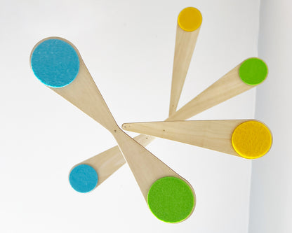 Bo Mobile hanging freely against a neutral background, showcasing its sculptural curved wooden arms and soft felt circles. This modern baby mobile is designed to float and spin gently, creating a calming visual experience for babies in their crib. Ideal for Scandinavian nursery decor, gender-neutral baby rooms, and minimalist interiors, this handmade wooden mobile blends art, movement, and function beautifully.