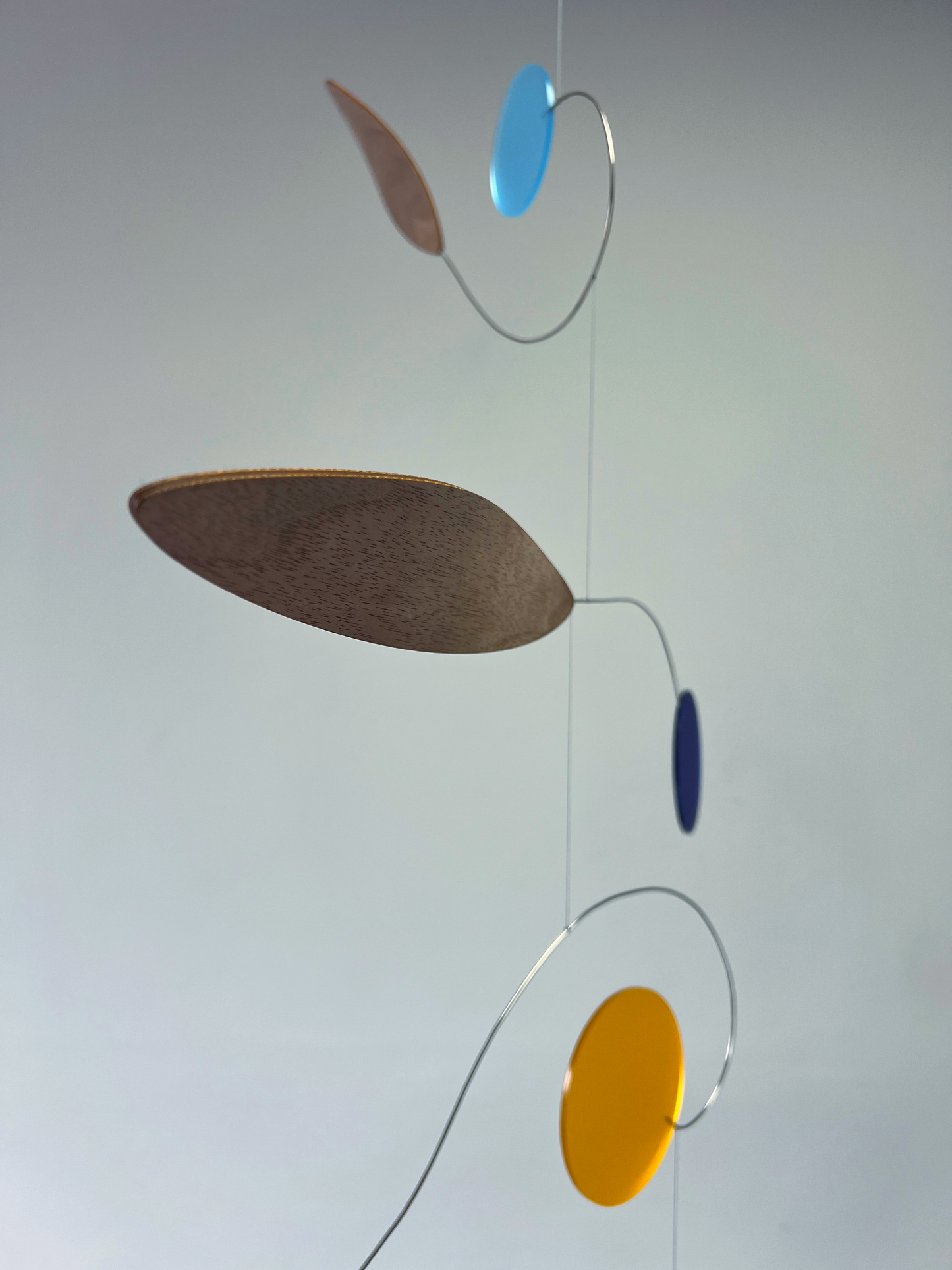 Colorful abstract hanging mobile with circular shapes on a plain background Rise MOBILE - Mid century Kinetic mobile sculpture In walnut and acrylic 