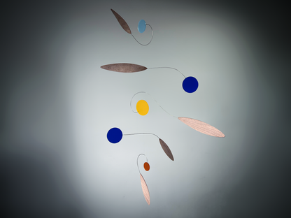 Colorful mobile with circular and leaf-shaped objects on a gray background Rise MOBILE - Mid century Kinetic mobile sculpture made of walnut and acrylic 